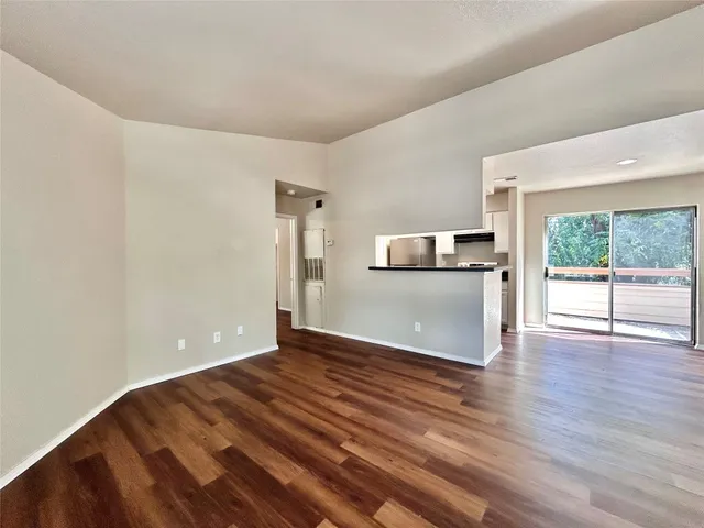 a view of a kitchen with wooden floor and electronic appliances