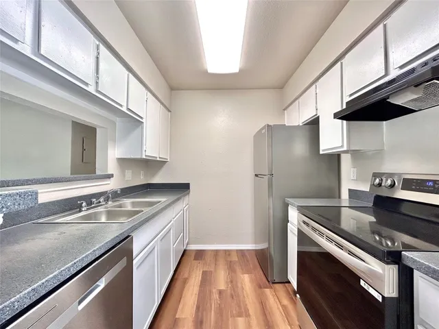 a kitchen with granite countertop a refrigerator and a stove