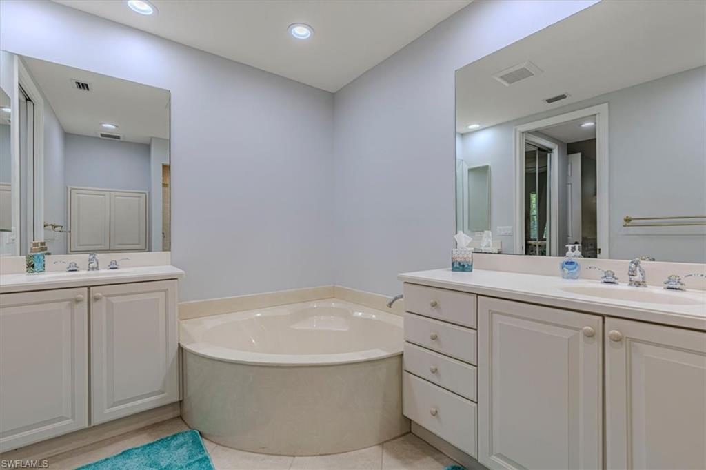 7837 Hawthorne Drive, Unit 1102 Naples, FL 34113 - Photo 14 of 33 Bathroom featuring two vanities, a bath, light tile patterned flooring, and recessed lighting