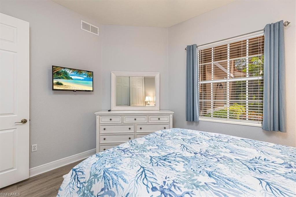 7837 Hawthorne Drive, Unit 1102 Naples, FL 34113 - Photo 19 of 33 Bedroom with wood finished floors and baseboards