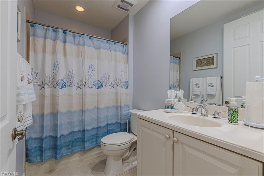 7837 Hawthorne Drive, Unit 1102 Naples, FL 34113 - Photo 20 of 33 Bathroom with vanity, light tile patterned flooring, and a shower with shower curtain
