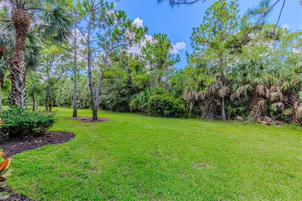 7837 Hawthorne Drive, Unit 1102 Naples, FL 34113 - Photo 25 of 33 View of grassy yard with view of scattered trees