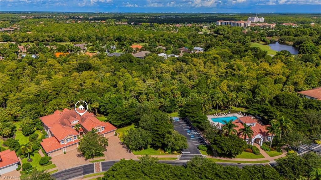 7837 Hawthorne Drive, Unit 1102 Naples, FL 34113 - Photo 30 of 33 Drone / aerial view of a pool area and a forest