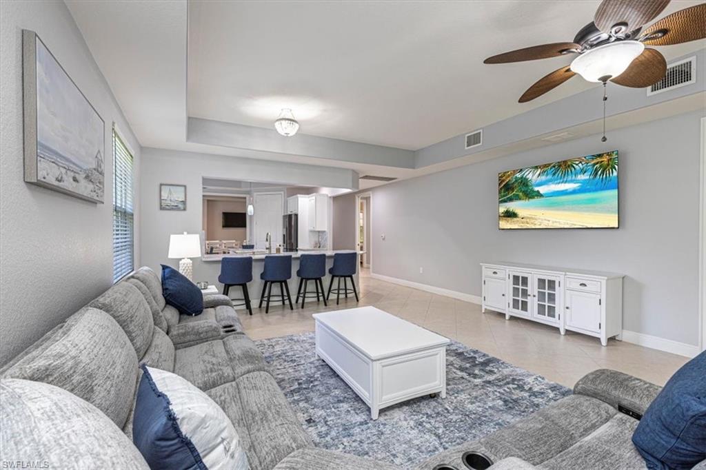 7837 Hawthorne Drive, Unit 1102 Naples, FL 34113 - Photo 5 of 33 Living area with a ceiling fan and light tile patterned floors