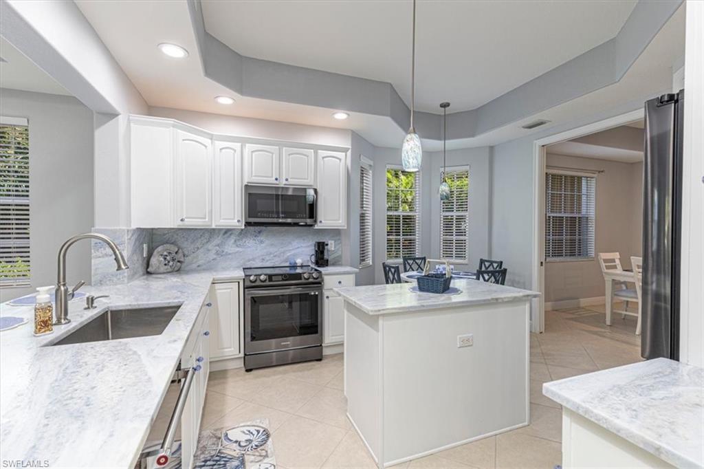 7837 Hawthorne Drive, Unit 1102 Naples, FL 34113 - Photo 8 of 33 Kitchen featuring stainless steel appliances, hanging light fixtures, white cabinets, light tile patterned floors, and recessed lighting