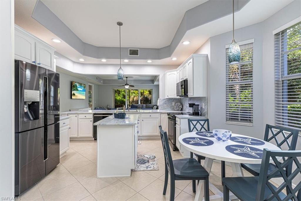 7837 Hawthorne Drive, Unit 1102 Naples, FL 34113 - Photo 9 of 33 Kitchen featuring black appliances, white cabinetry, decorative light fixtures, light tile patterned floors, and recessed lighting
