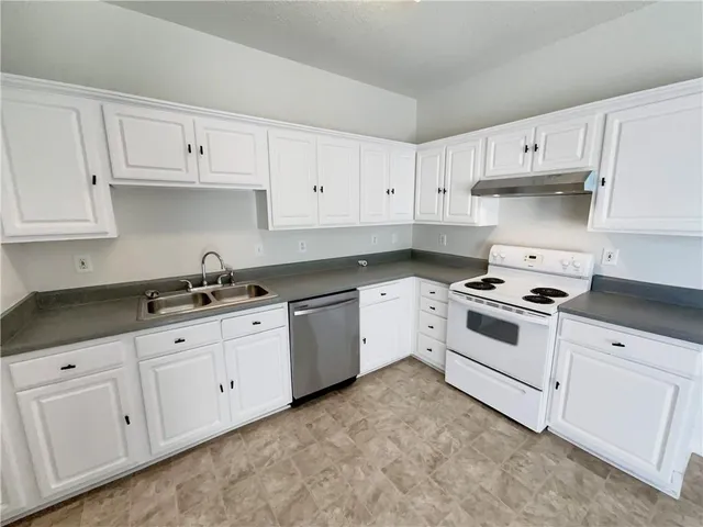 a white kitchen with granite top