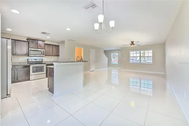 a kitchen with stainless steel appliances granite countertop a refrigerator and a stove top oven