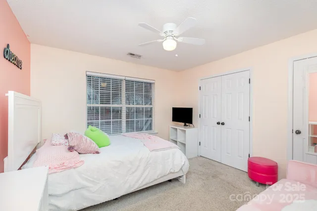 a bedroom with a bed a chandelier and a window