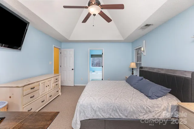a bedroom with a bed and a flat tv screen on dresser