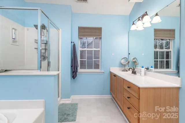 a bathroom with a double vanity sink mirror and shower