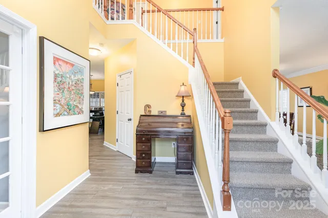 a view of a hallway with wooden floor and staircase