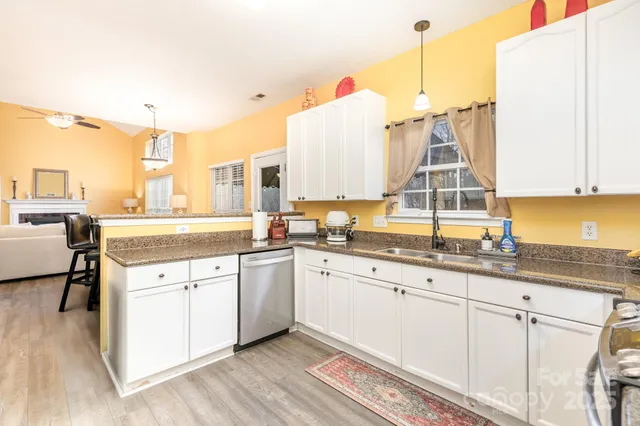 a kitchen with granite countertop white cabinets and white appliances