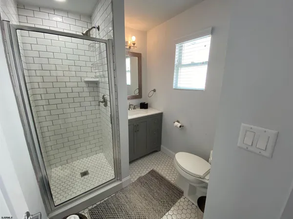 a bathroom with a shower a toilet and a sink