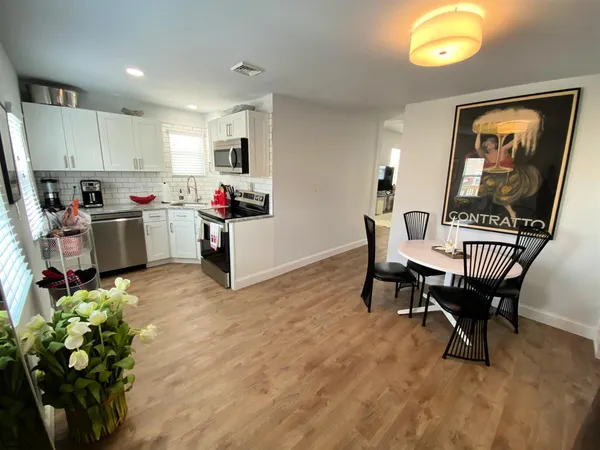 a living room with furniture and a dining table with kitchen view