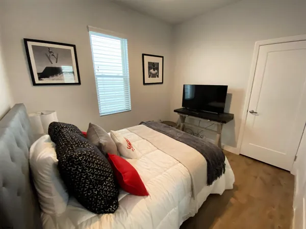 a bedroom with bed and a flat screen tv