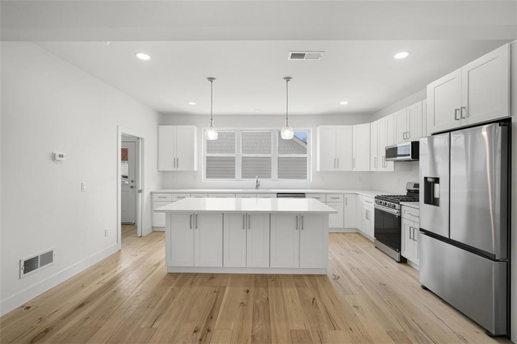 211 Green Street Pittsburgh, PA 15221 - Photo 12 of 22 a kitchen with white cabinets and stainless steel appliances