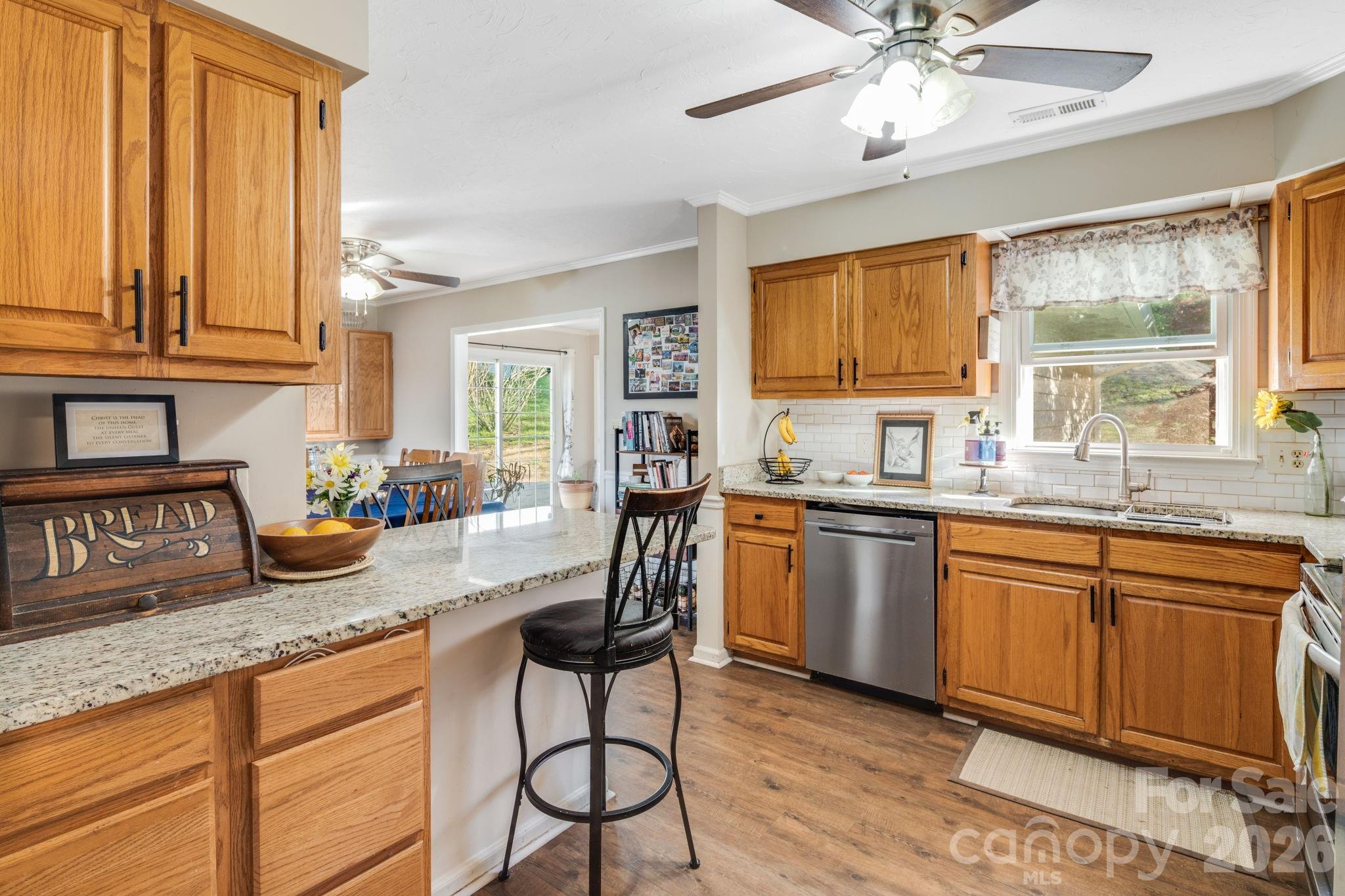 99 South Rowe Road Hendersonville, NC 28792 - Photo 12 of 40 a kitchen with granite countertop a stove a sink and a refrigerator