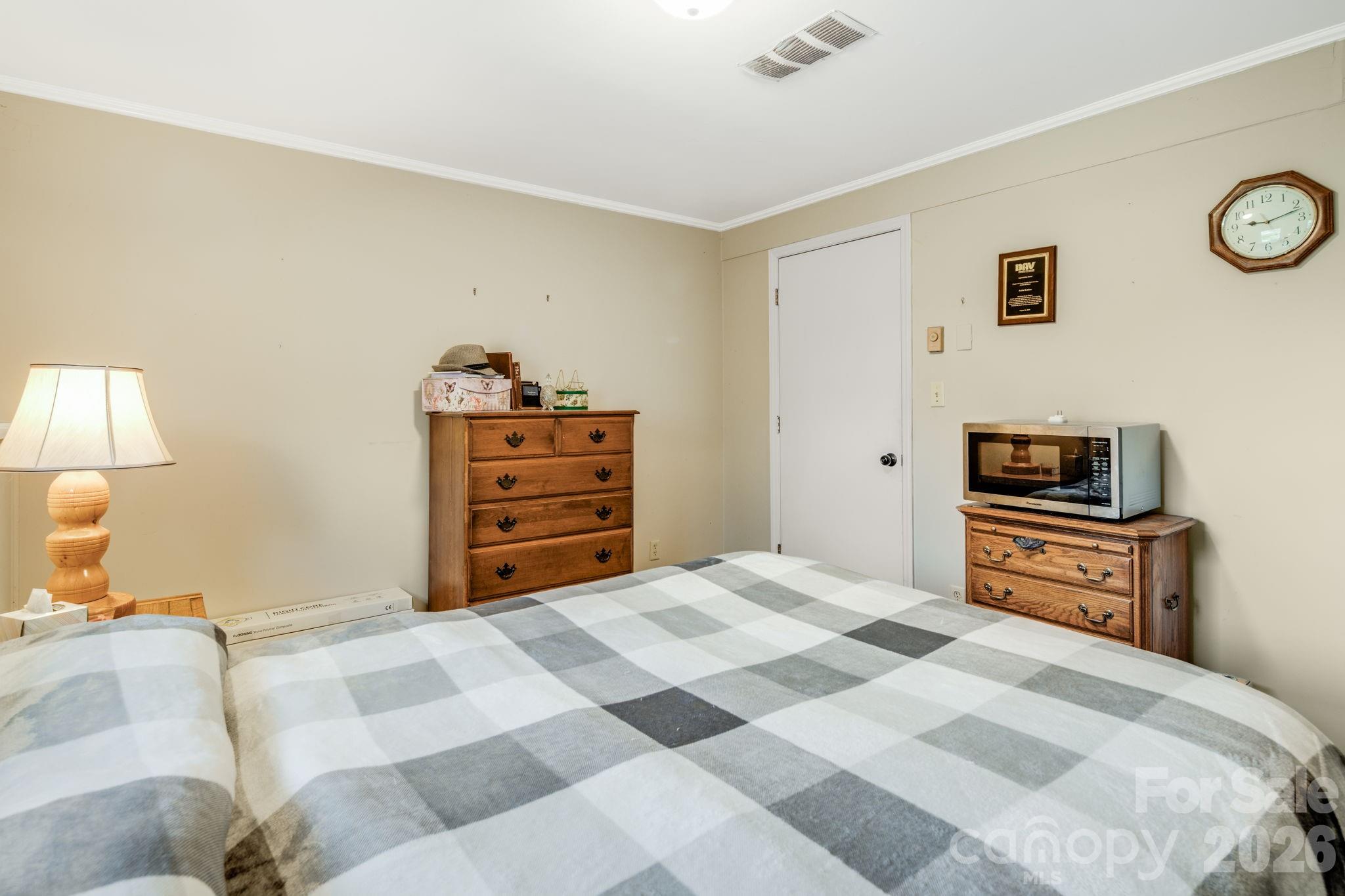 99 South Rowe Road Hendersonville, NC 28792 - Photo 16 of 40 a bedroom with a bed and a lamp