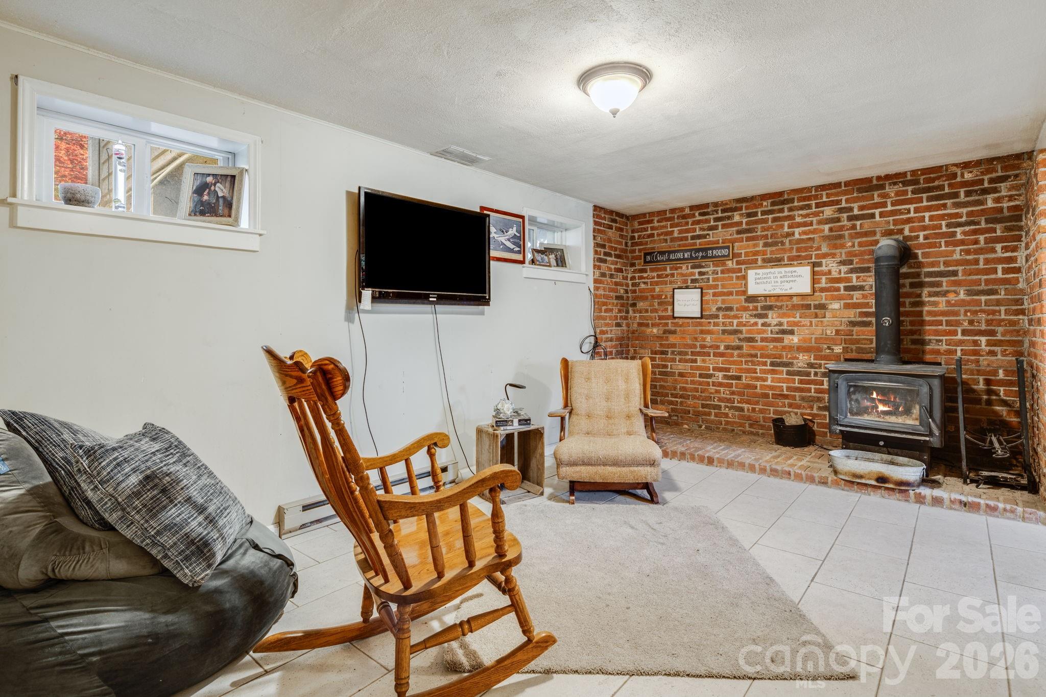 99 South Rowe Road Hendersonville, NC 28792 - Photo 28 of 40 a living room with furniture a flat screen tv and a fireplace