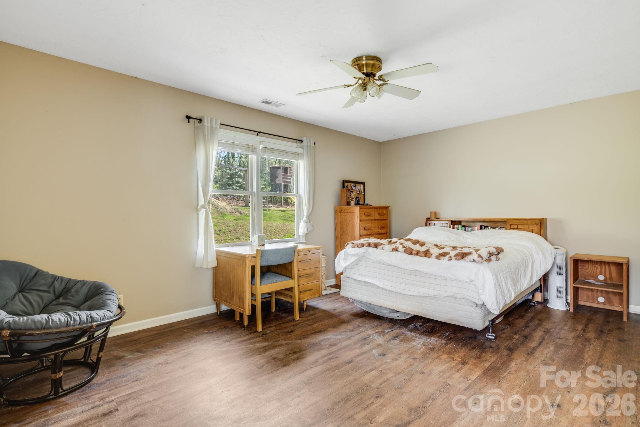 99 South Rowe Road Hendersonville, NC 28792 - Photo 31 of 40 a spacious bedroom with a bed and a chandelier
