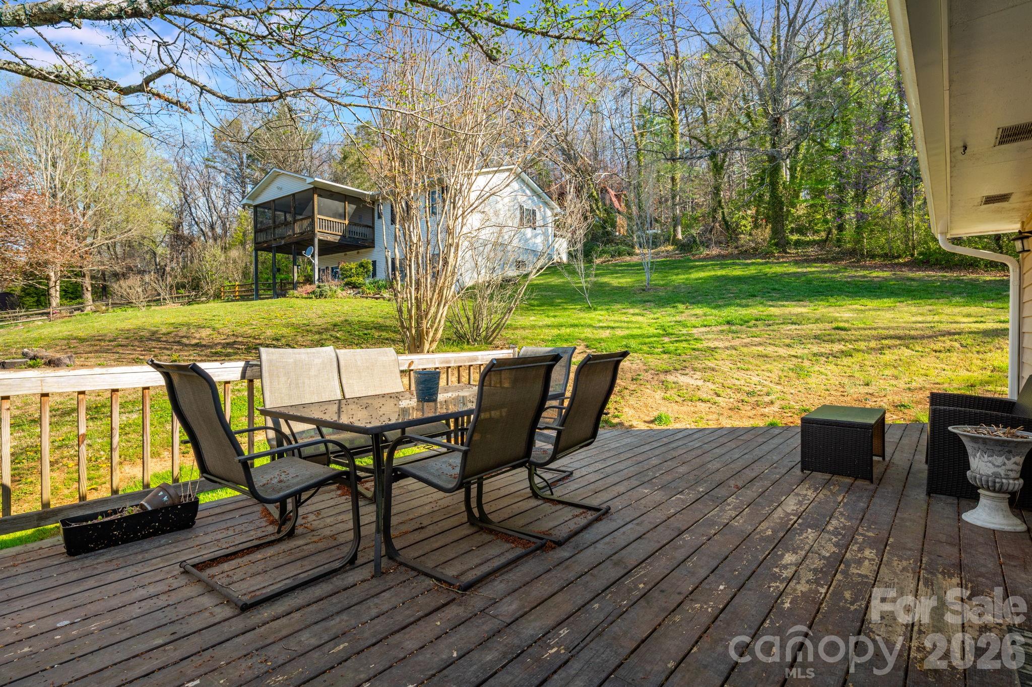 99 South Rowe Road Hendersonville, NC 28792 - Photo 34 of 40 a view of a roof deck with table and chairs floor to house with wooden floor