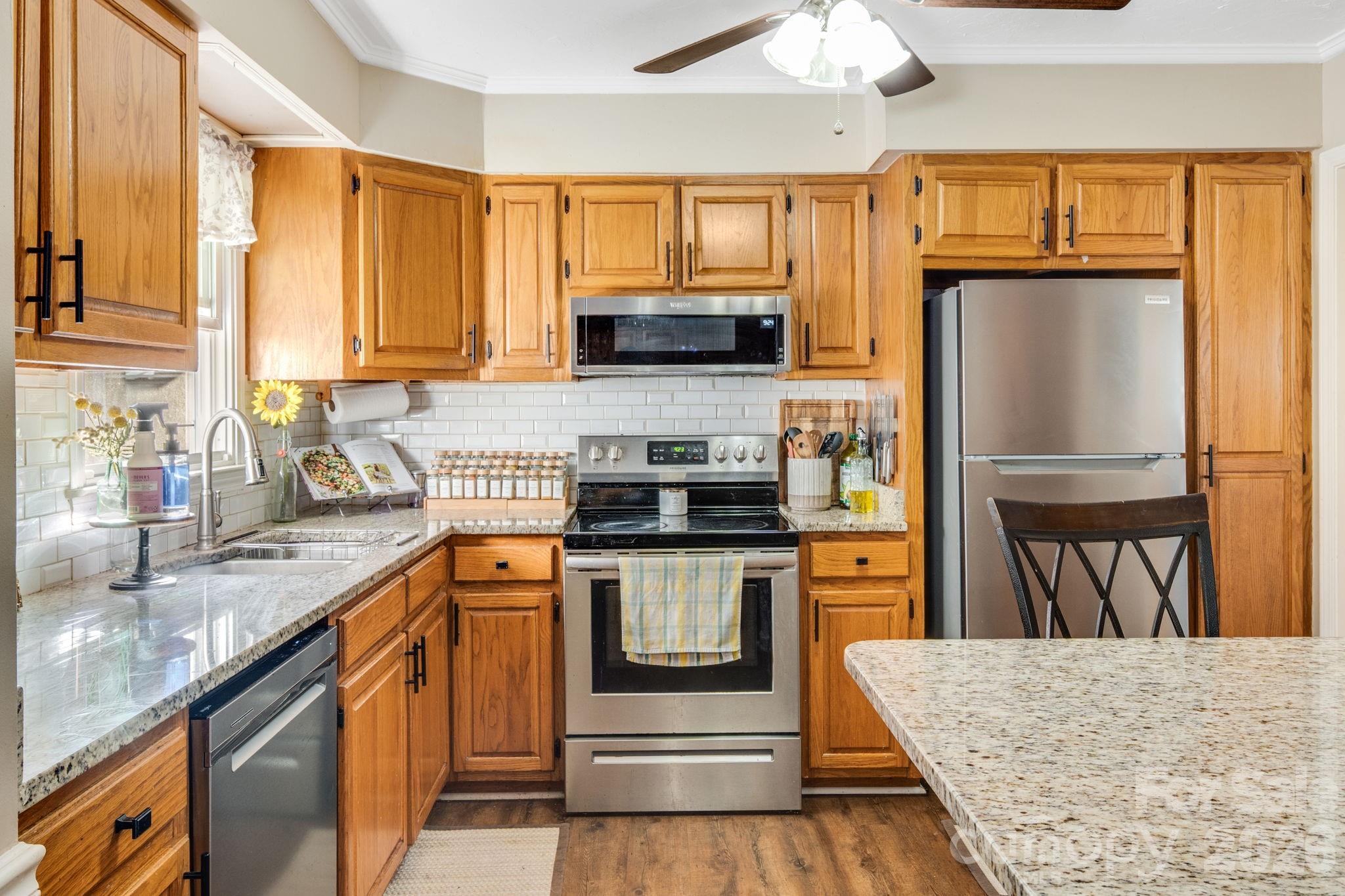 99 South Rowe Road Hendersonville, NC 28792 - Photo 10 of 40 a kitchen with stainless steel appliances granite countertop a stove a sink and a refrigerator