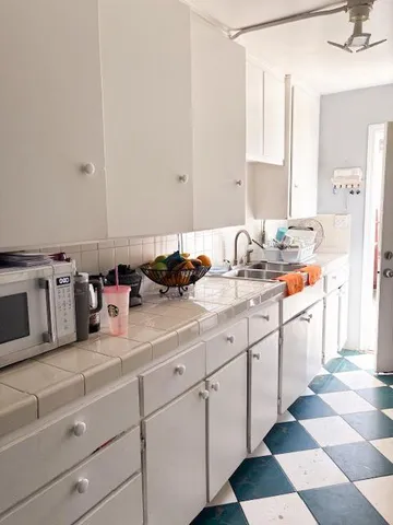 a kitchen with a sink window and cabinets