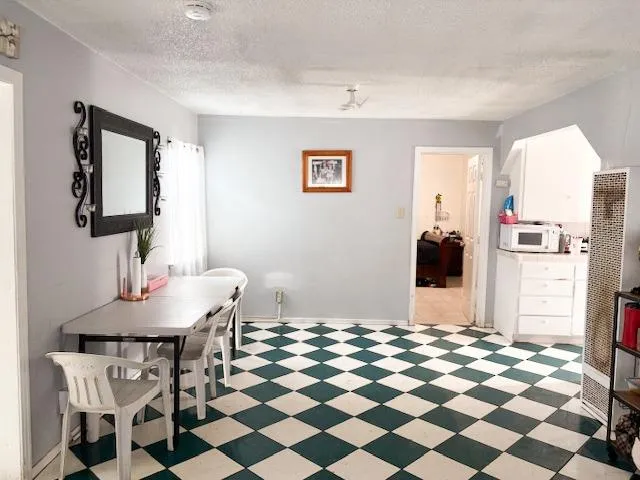 a living room with a black white checkered floor with couches chair and a coffee table