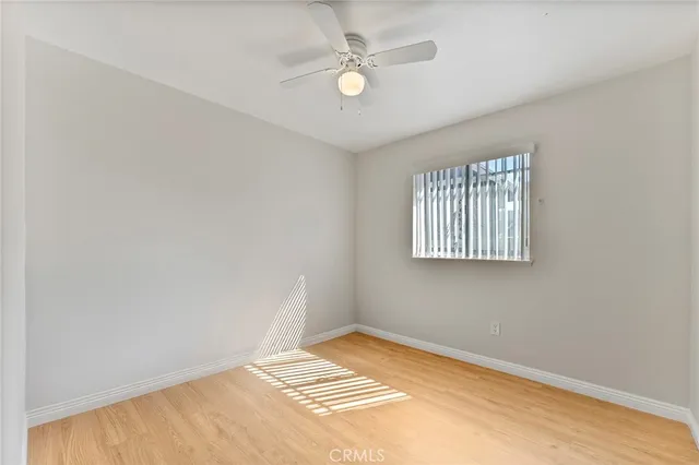 an empty room with windows and ceiling fan