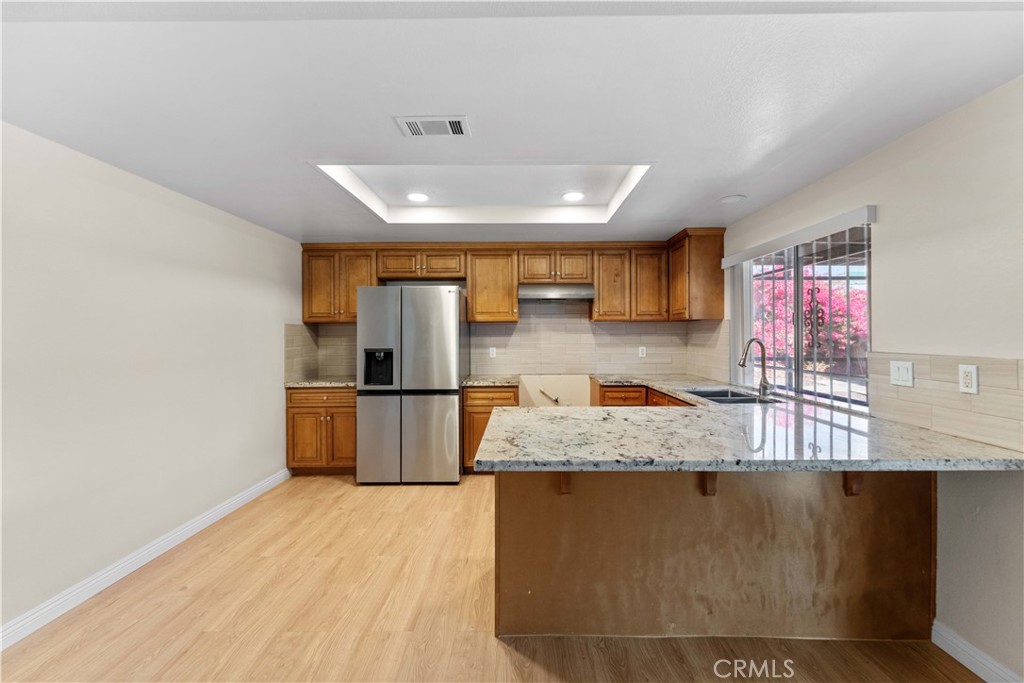 27875 Rainbow Lane Highland, CA 92346 - Photo 4 of 37 a large kitchen with stainless steel appliances granite countertop a sink a stove counter space and cabinets