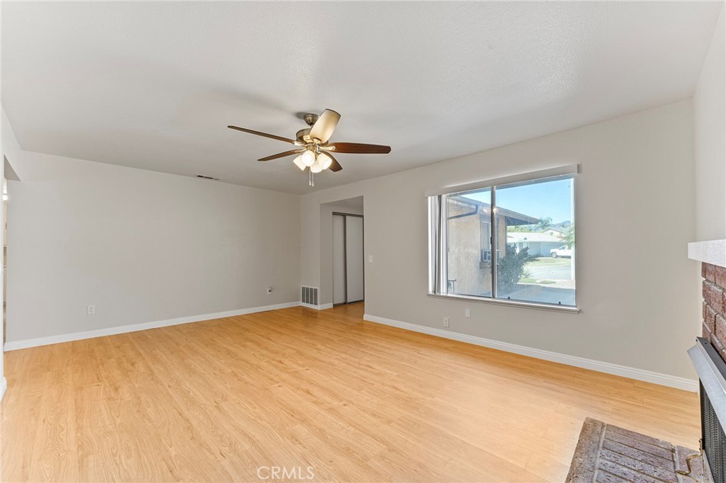 27875 Rainbow Lane Highland, CA 92346 - Photo 9 of 37 a view of an empty room with chandelier fan and fire place