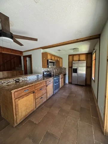 a large kitchen with stainless steel appliances granite countertop a stove and a sink