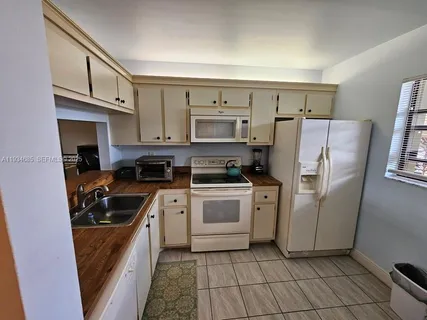 a kitchen with a stove a refrigerator and a sink