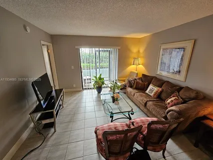 a living room with furniture a window and a flat screen tv
