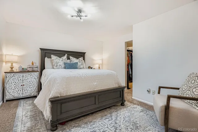 a bed sitting in a bedroom and chandelier