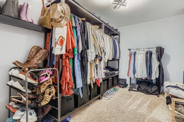 a view of walk in closet with clothes