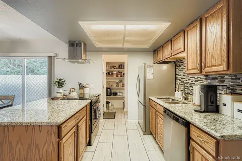 a kitchen with stainless steel appliances granite countertop a sink stove and refrigerator
