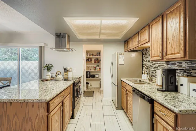 a kitchen with stainless steel appliances granite countertop a sink stove and refrigerator