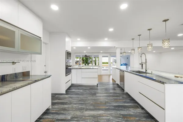 a large kitchen with kitchen island a sink stainless steel appliances and cabinets