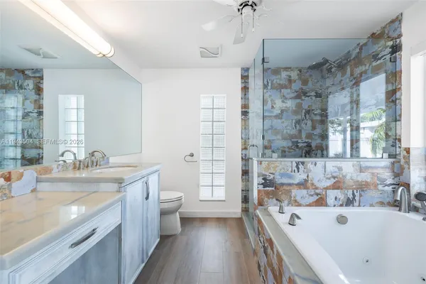 a spacious bathroom with a tub sink shower and mirror