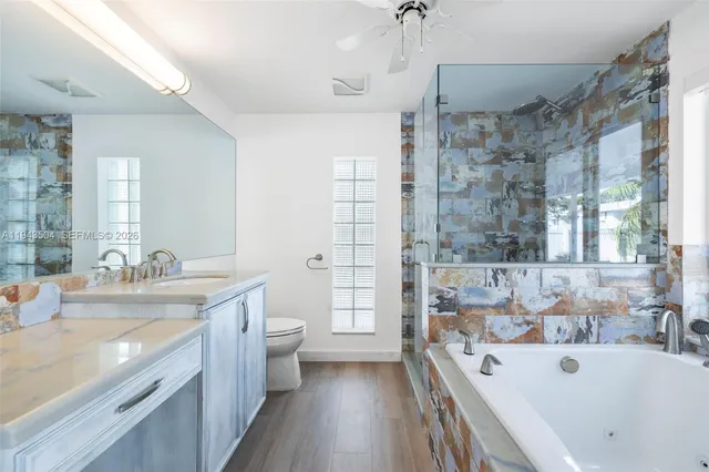 a spacious bathroom with a tub sink shower and mirror