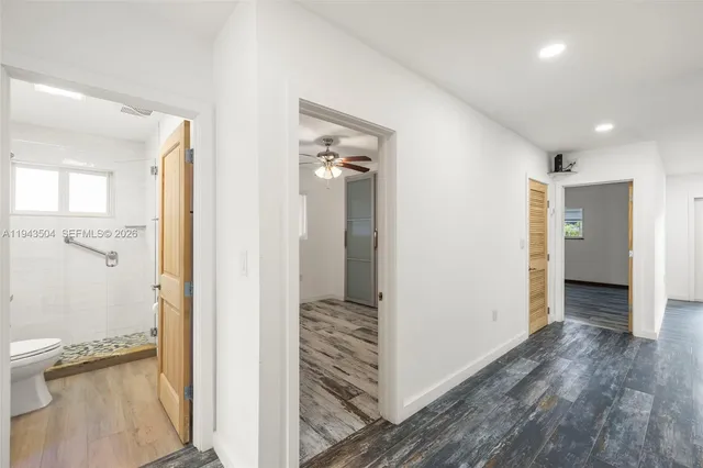 a view of a hallway with wooden floor and closet