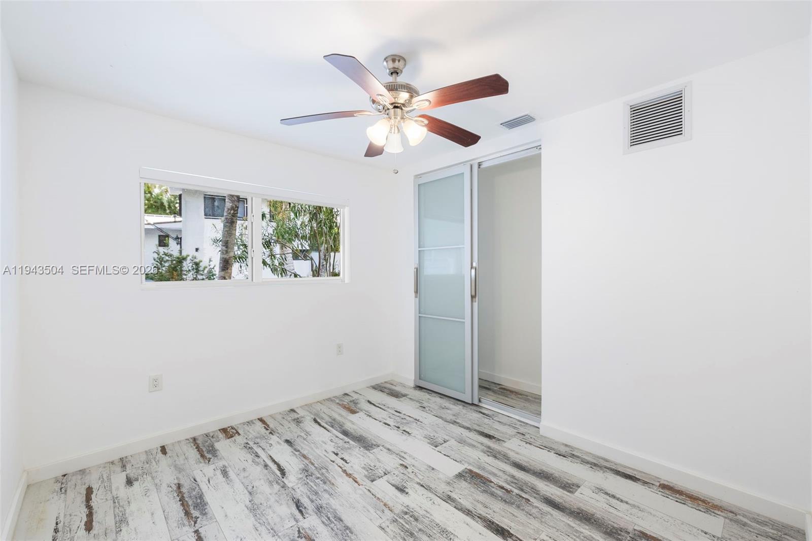 1895 Ixora Road North Miami, FL 33181 - Photo 27 of 42 a view of a livingroom with wooden floor and a ceiling fan