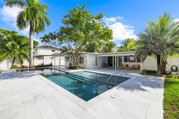 a view of a house with swimming pool and sitting area
