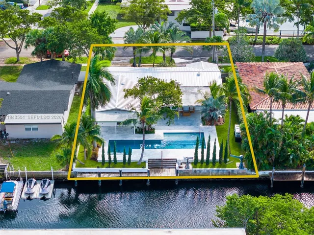 an aerial view of a house with a yard swimming pool a patio and yard