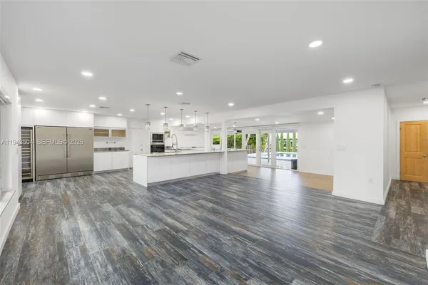 a view of kitchen with kitchen island large window and wooden floor
