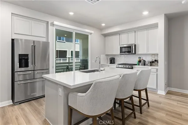 a kitchen with kitchen island a refrigerator and a stove top oven