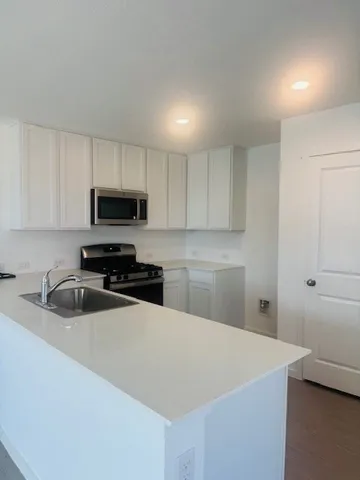 a kitchen with a sink a stove and cabinets