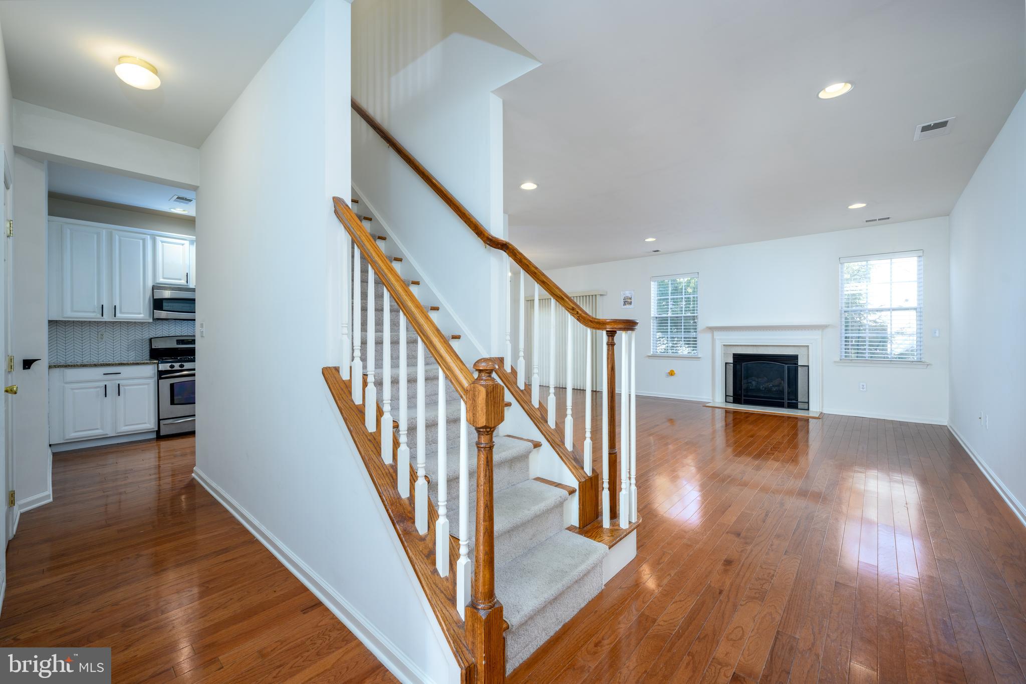 249 Concord Place Pennington, NJ 08534 - Photo 3 of 22 a view of a hallway with wooden floor and a kitchen
